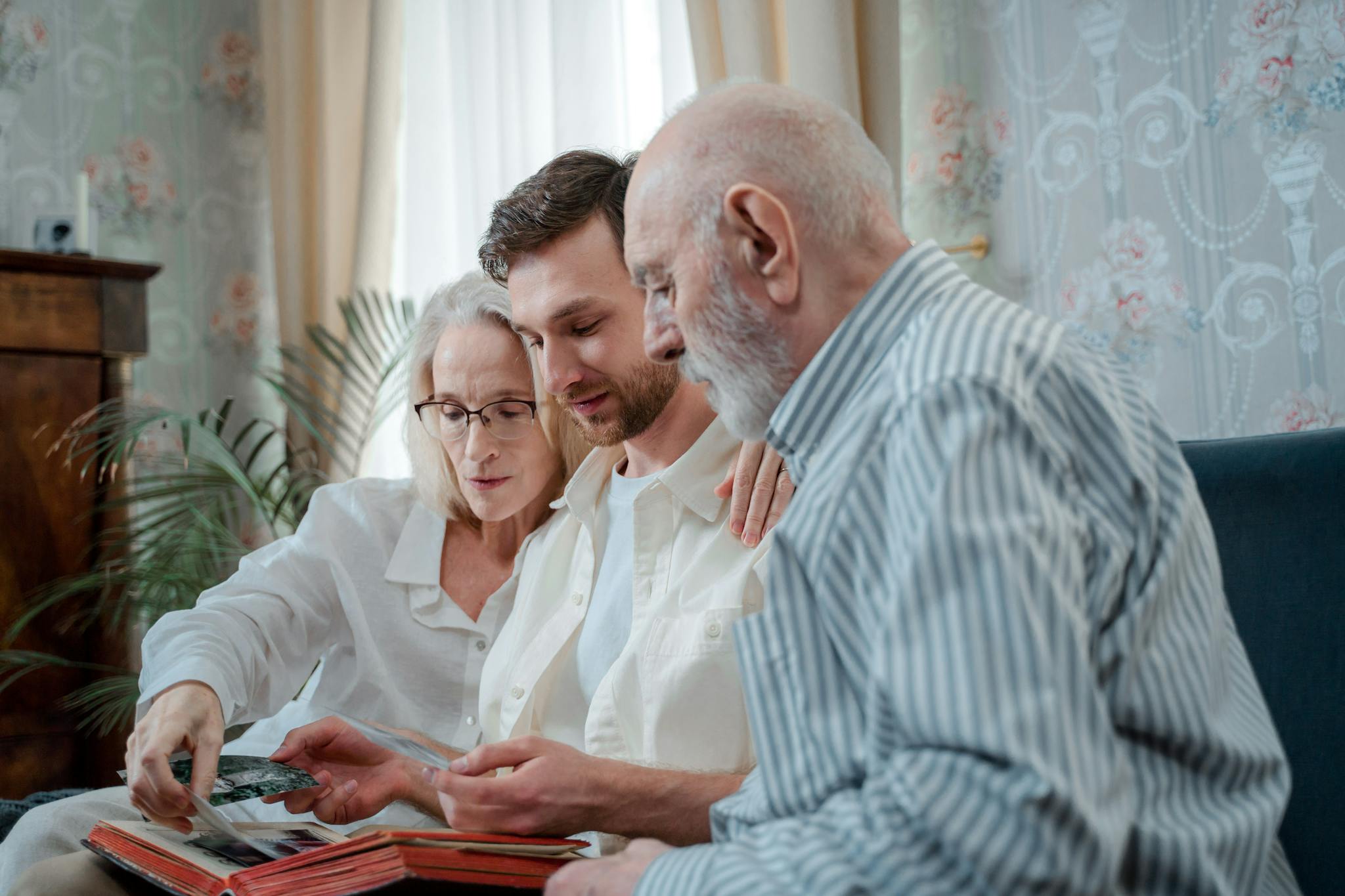 A family cherishing memories by browsing a photo album together indoors.