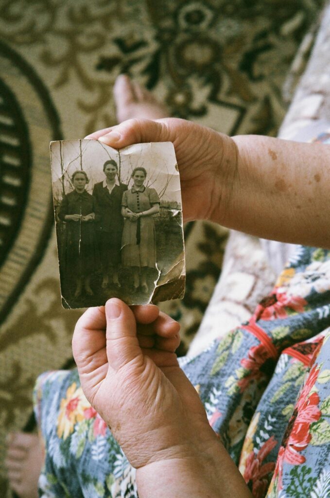 Close-up of elderly hands holding a vintage family photo, evoking nostalgia and memories.
